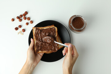 Concept of tasty breakfast with chocolate paste on white background