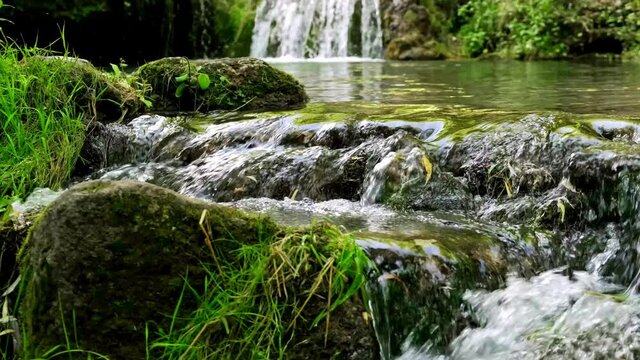 Waterfall on mountain river in the forest. Panoramic beautiful deep forest waterfall. Waterfall river stream in green nature forest landscape. Mountain river with forest landscape. Mossy waterfall.