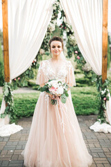Fototapeta premium Beauty portrait of bride wearing fashion wedding dress with feathers with luxury delight make-up and hairstyle