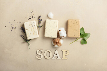 Natural soap bars - lavender, cotton, patchouli - ingredients and wooden letters on natural stone background, flat lay - obrazy, fototapety, plakaty