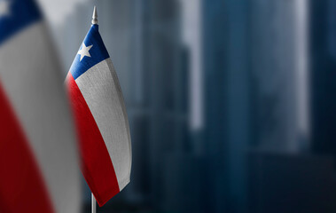Small flags of Chile on a blurry background of the city