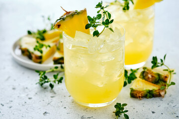 Pineapple cocktail with pulp in a glass and thyme.