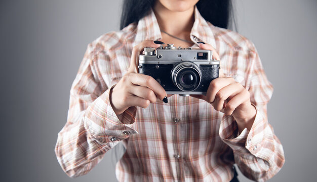 young woman holding vintage camera