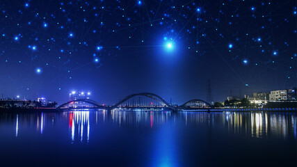 night view of the city with bridge over the river within data transmission networking lines technology.