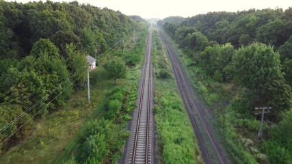 Fototapeta premium Railway tracks through forests and fields.