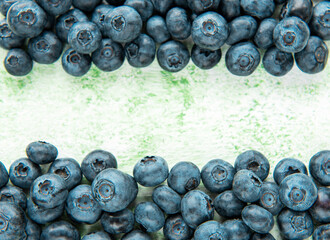 Blueberries on a green wooden background