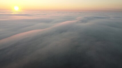 Morning sunrise over a thick autumn fog that covered the entire earth's surface.