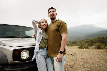 Young couple is on romantic trip to the mountains by car