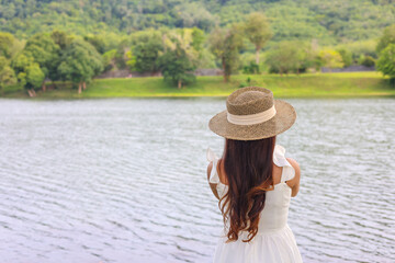 Young happy woman on top of hill enjoy beautiful view of sky and mountains , Asia woman traveler,travel concept