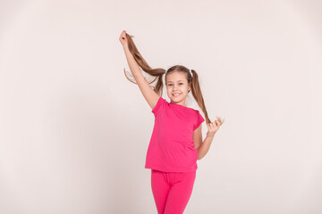 happy child on a white background. a girl in a pink T-shirt and pants.