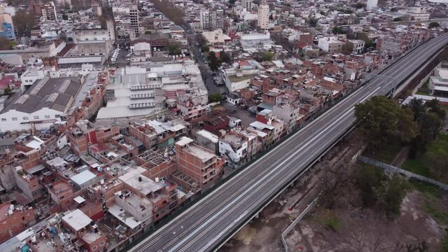 Aerial flight over poor neighborhood beside highway road in Buenos Aires -  La Carbonilla,Villa Miseria