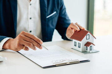 The real estate agent is explaining the house style to the clients who come to contact to see the...