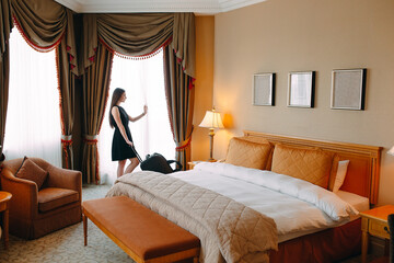 Young women with suitcase are staying in a hotel room.