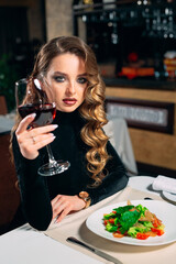 Young beautiful woman drinking wine in a restaurant.