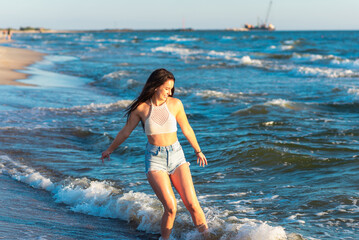 Fototapeta premium Young woman playing in the sea.woman enjoying in sea water .Cheerful young woman having fun on the summer beach.