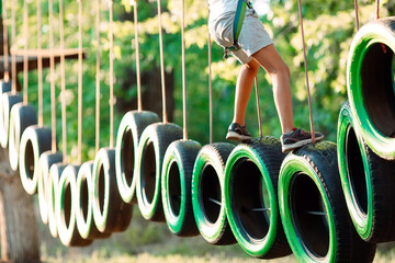 rope park. A boy passes an obstacle on tires in a rope Park.