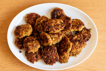 Homemade cutlets,meatballs white plate on a table yellow background.Delicious homemade cutlets.Selective focus.