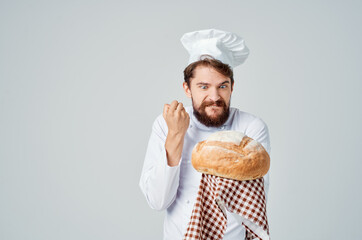 bearded man chef with bread in hand light background