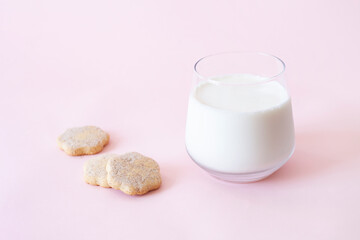 Cookies and glass of milk in pink background