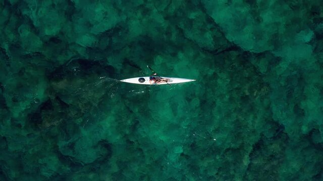 Single seat canoe rowing over a shallow lagoon, Aerial view.
