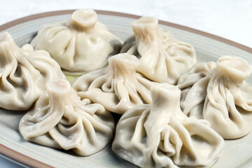 Georgian dumplings Khinkali with meat on white plate.