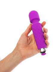 silicone vibrator massager in a female hand on a white background