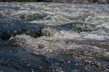 Fast flowing cold water mountain stream, flowing stormy stream stream, nature outdoors, fresh stream dark blue water