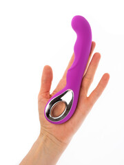silicone vibrator massager in a female hand on a white background