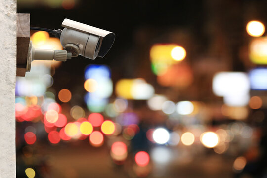 CCTV camera system on colorful bokeh of road at night background.