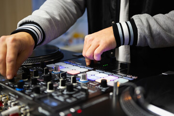 Hands of dj mixing music on audio mixer. Professional disc jockey equipment
