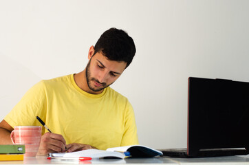 College student doing homework at home. Smart man watching a virtual classroom from home. young man...