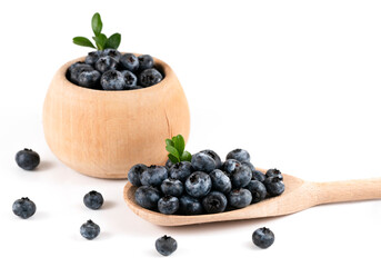 Wooden spoon full of fresh ripe blueberries on white background