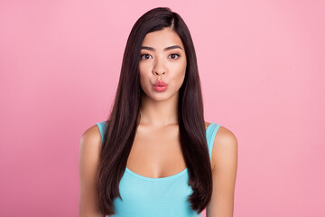 Fototapeta premium Photo of gorgeous young brown hairdo lady blow kiss wear blue top isolated on pastel pink color background