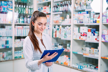 pharmacist chemist woman working in pharmacy drugstore with tablet.