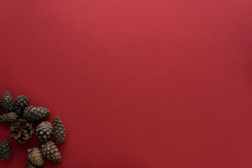 Christmas composition. Spruce cones on a red background. Flat lay, top view, space for text