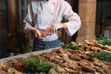 The chef opens oysters in the restaurant.