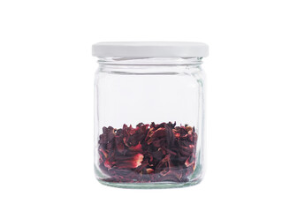 Hibiscus tea in a transparent glass jar. Close-up. Isolated on white background.