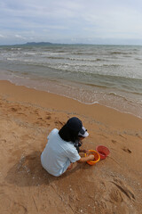 Obraz premium Asian boy and mother doing vacation activities on the beach.