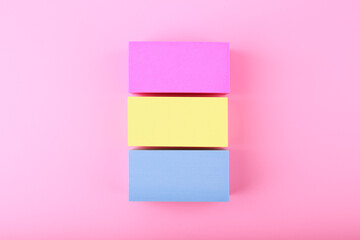 Flat lay with pansexual flag made of pink, yellow and blue rolls on bright pink background. Concept of pansexual community, sexual minorities, equal right and tolerance