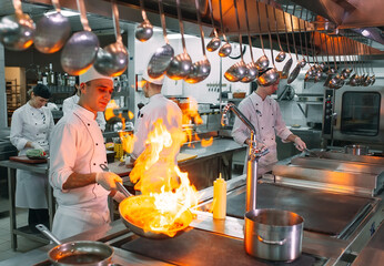 Modern kitchen. Cooks prepare meals on the stove in the kitchen of the restaurant or hotel. The fire in the kitchen.