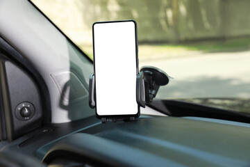 Car holder with modern mobile phone on windshield of automobile. Mockup for design