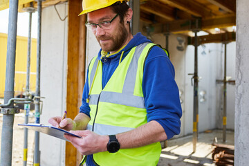 Handwerker beim Hausbau erstellt Kostenvoranschlag