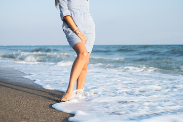 Woman legs walking on the beach