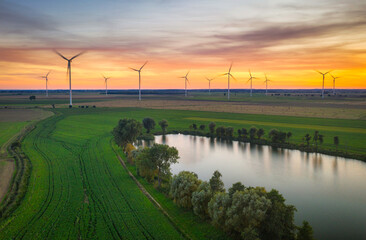 Amazing sunset over the field with wind turbines in Poland