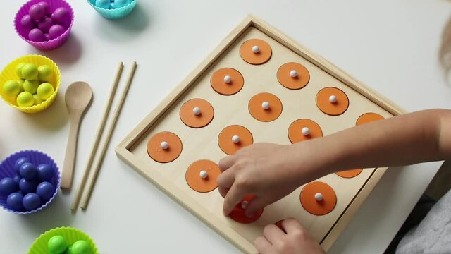 A child playing a children's educational game for the development of memory. It is necessary to find two of the same pictures. The concept of kids leisure and preschool education.