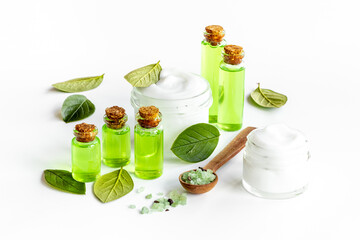 Tea tree cosmetics with essential oil and green leaves