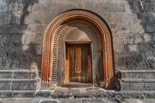 entrance portal to the ancient armenian Saint Gevorg Church with a wooden carved door. Religious and history concept