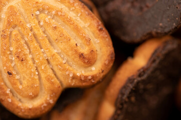 Curly cookies covered with chocolate icing, background image, close-up, selective focus.