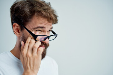 man vision problems in white t-shirt light background