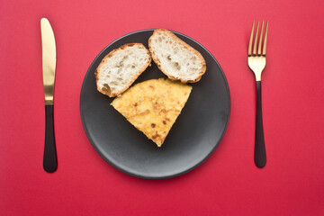 Spanish potato omelette, on red background, in studio, Asturias